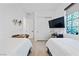 Neutral bedroom with two twin beds, wood-style flooring, and large window at 12 Tatahatso Point St, Henderson, NV 89011