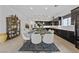 Elegant dining room with modern chandelier, adjacent to kitchen, featuring sleek cabinets at 12 Tatahatso Point St, Henderson, NV 89011