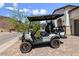 Close-up of a gray golf cart parked in front of home on a paver driveway with desert landscaping at 12 Tatahatso Point St, Henderson, NV 89011