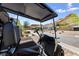 Golf cart parked on paved driveway in front of home features custom seats and mountain views at 12 Tatahatso Point St, Henderson, NV 89011