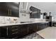 Stylish kitchen featuring black cabinets, subway tile backsplash, and gold hardware at 12 Tatahatso Point St, Henderson, NV 89011