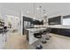 Open-concept kitchen with black cabinets, white countertops, and stainless steel appliances at 12 Tatahatso Point St, Henderson, NV 89011