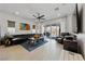 Inviting living room with a large black leather couch, ceiling fan, neutral walls, and access to an outdoor balcony at 12 Tatahatso Point St, Henderson, NV 89011