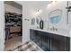 Modern main bathroom featuring double sinks, granite countertop, and walk-in closet at 12 Tatahatso Point St, Henderson, NV 89011