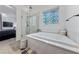 Luxurious main bathroom featuring a soaking tub, a glass-enclosed shower, and decorative window at 12 Tatahatso Point St, Henderson, NV 89011