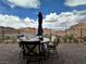 This home's outdoor patio set includes four chairs with cushions, a round table, umbrella and mountain views at 12 Tatahatso Point St, Henderson, NV 89011