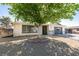 Landscaped front yard with desert landscaping, gravel, mature tree, and wrought iron gate at 1304 Virgil St, Las Vegas, NV 89110