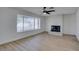 Open-concept living room featuring a fireplace, ceiling fan, large windows and wood floors at 1304 Virgil St, Las Vegas, NV 89110
