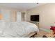 Simple bedroom with a bed, TV on stand, neutral color walls, and a view into the hallway at 1430 October Oak Ave, Las Vegas, NV 89123