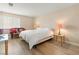 Neutral bedroom with light wood floors, a full bed, decorative pillows, and natural light from the window at 1430 October Oak Ave, Las Vegas, NV 89123