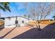 View of the backyard featuring stone landscaping, trees, and the rear of the home at 1720 Hassett Ave, Las Vegas, NV 89104