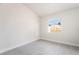 An empty bedroom has white walls, light-colored flooring and large window with neighborhood views at 1720 Hassett Ave, Las Vegas, NV 89104