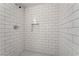 Close up of a white tiled shower with a shower niche and hexagon floor at 1720 Hassett Ave, Las Vegas, NV 89104