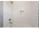A tiled bathtub and shower feature white subway tiles and brushed steel fixtures at 1720 Hassett Ave, Las Vegas, NV 89104