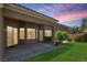 View of covered patio and private yard with manicured lawn and mature trees at 2251 Summerwind Cir, Henderson, NV 89052