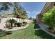 Manicured backyard has lush green grass, mature trees, and decorative rock landscaping at 2251 Summerwind Cir, Henderson, NV 89052