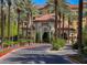 Elegant building with a terracotta tile roof and grand entrance framed by palm trees and manicured landscaping at 2251 Summerwind Cir, Henderson, NV 89052