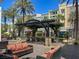 Comfortable courtyard seating area with sofas, palm trees, and a pergola, perfect for relaxation at 2251 Summerwind Cir, Henderson, NV 89052