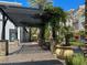 Charming outdoor walkway featuring benches, planters, and a pergola, enhanced by lush greenery and palm trees at 2251 Summerwind Cir, Henderson, NV 89052