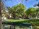 A view of the community park and playground with mature trees and benches at 2251 Summerwind Cir, Henderson, NV 89052