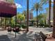 Relaxing outdoor shopping area with benches, shade, and lush landscaping under a sunny sky at 2251 Summerwind Cir, Henderson, NV 89052