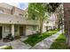 Townhouse exterior featuring a sidewalk, trimmed green lawn, and mature trees providing shade at 2681 Ruthe Duarte Ave, Las Vegas, NV 89121