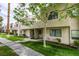 Townhouse exterior featuring a sidewalk, trimmed green lawn, and mature trees providing shade at 2681 Ruthe Duarte Ave, Las Vegas, NV 89121