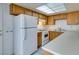 Cozy kitchen featuring wooden cabinets, white appliances, and updated tile flooring at 2681 Ruthe Duarte Ave, Las Vegas, NV 89121