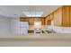 Well-lit kitchen featuring wooden cabinets, white appliances, and a convenient breakfast bar at 2681 Ruthe Duarte Ave, Las Vegas, NV 89121