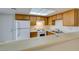 Well-lit kitchen featuring wooden cabinets, white appliances, and a convenient breakfast bar at 2681 Ruthe Duarte Ave, Las Vegas, NV 89121
