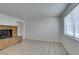 A living room featuring a cozy brick fireplace, tiled flooring, and a bright window at 2681 Ruthe Duarte Ave, Las Vegas, NV 89121