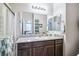 Bathroom with a large mirror, granite countertop, wood cabinets, and shower with glass doors at 2727 Chinaberry Hill St, Laughlin, NV 89029