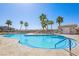 Community pool with turquoise water, mature palm trees, sun loungers, and an adjacent service building at 2727 Chinaberry Hill St, Laughlin, NV 89029