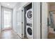 Convenient laundry area with stacked washer and dryer, tile floor, and access to the outside and bathroom at 2727 Chinaberry Hill St, Laughlin, NV 89029