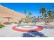 Community splash pad featuring a colorful rainbow water feature, picnic tables with sunshades and desert landscaping at 2727 Chinaberry Hill St, Laughlin, NV 89029