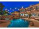 Backyard view featuring a freeform pool and hot tub, ambient string lights, and a covered patio for outdoor gatherings at 2749 Carolina Blue Ave, Henderson, NV 89052