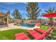 Backyard features a pristine pool, rock waterfall, dining and lounge seating with beautiful views at 2749 Carolina Blue Ave, Henderson, NV 89052