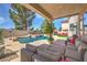 This backyard has a pool and waterfall feature, plus a covered patio with comfortable lounge seating at 2749 Carolina Blue Ave, Henderson, NV 89052