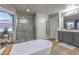 Modern bathroom showcasing soaking tub, tiled floors, large windows, and a glass enclosed shower at 2749 Carolina Blue Ave, Henderson, NV 89052