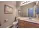 This bathroom has a toilet and vanity with cream-colored walls and a large mirror at 2749 Carolina Blue Ave, Henderson, NV 89052