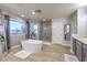 Bright bathroom showcasing soaking tub, tiled floors, large windows, and a separate glass enclosed shower at 2749 Carolina Blue Ave, Henderson, NV 89052