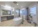 Bright bathroom showcasing soaking tub, tiled floors, large windows, and a separate glass enclosed shower at 2749 Carolina Blue Ave, Henderson, NV 89052