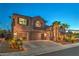 Charming two-story home with landscaped yard, swaying palm trees, and a spacious three-car garage at twilight at 2749 Carolina Blue Ave, Henderson, NV 89052