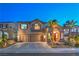 Charming two-story home with landscaped yard, swaying palm trees, and a spacious three-car garage at twilight at 2749 Carolina Blue Ave, Henderson, NV 89052