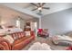 Cozy living room featuring hardwood floors, leather couch, and open layout to the sleeping quarters at 2749 Carolina Blue Ave, Henderson, NV 89052