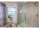 Bright bathroom showcasing tiled glass shower with window and decorative shelving unit at 2749 Carolina Blue Ave, Henderson, NV 89052