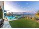 Beautiful backyard featuring a swimming pool with a waterfall, an inset hot tub, an outdoor seating area, and landscape lighting at 286 Shaded Canyon Dr, Henderson, NV 89012