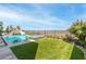 Inviting backyard featuring a pool with waterfall, spa, artificial grass, and city views at 286 Shaded Canyon Dr, Henderson, NV 89012