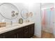 Modern bathroom with a double sink, quartz countertop, stylish light fixtures, and wood flooring at 286 Shaded Canyon Dr, Henderson, NV 89012