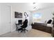 Well-lit bedroom with brick accent wall, sleek black gaming setup, and comfortable bed with storage at 286 Shaded Canyon Dr, Henderson, NV 89012